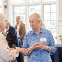 Diane Richmond standing and listening to another women